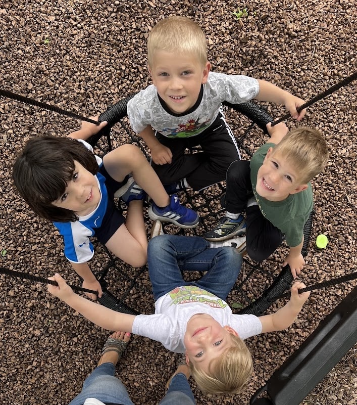 Boys on tire swing playing together