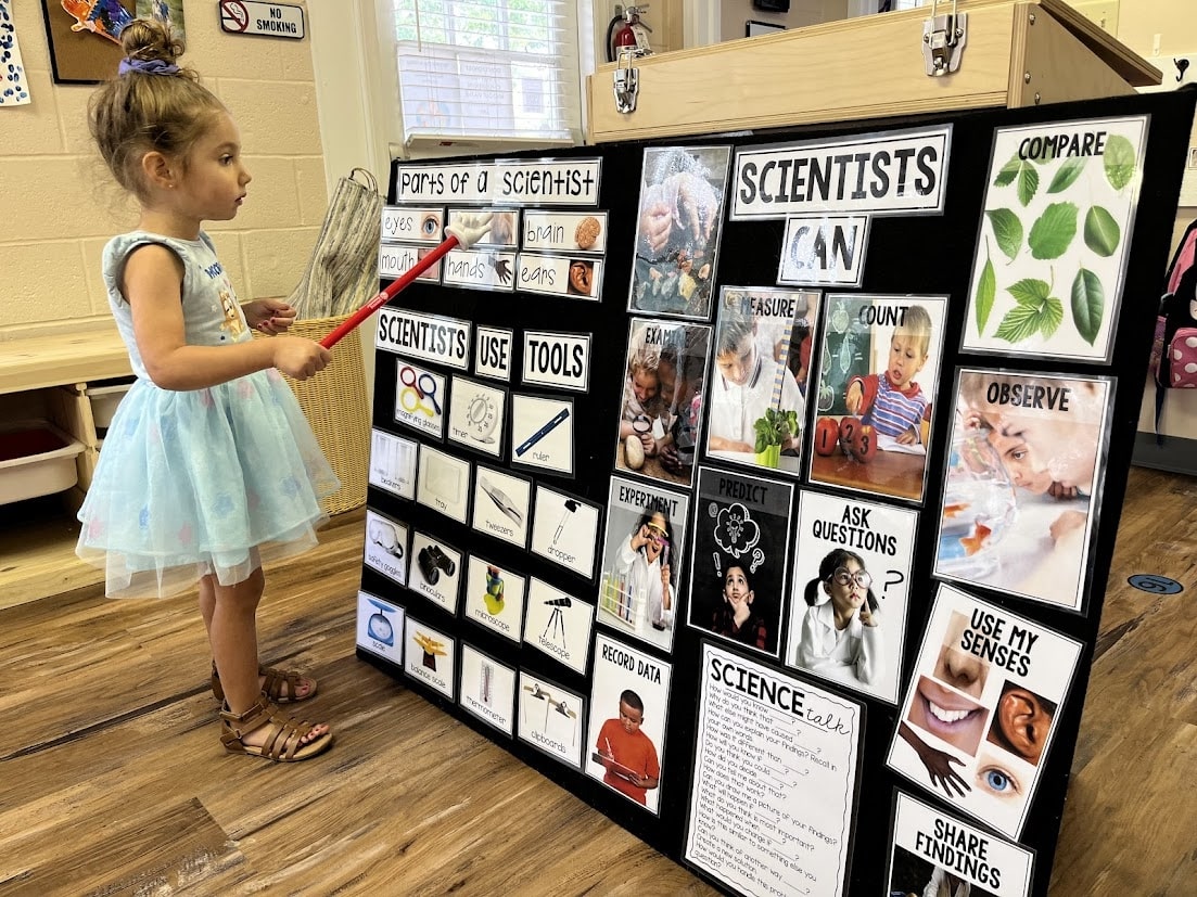 Preschool_girl_pointing_to_scientist_board