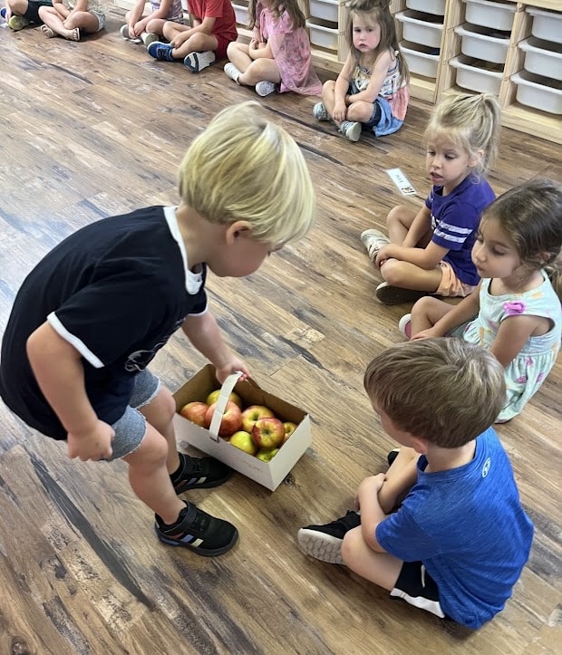 Student peer teaching classmates about the variety of apples