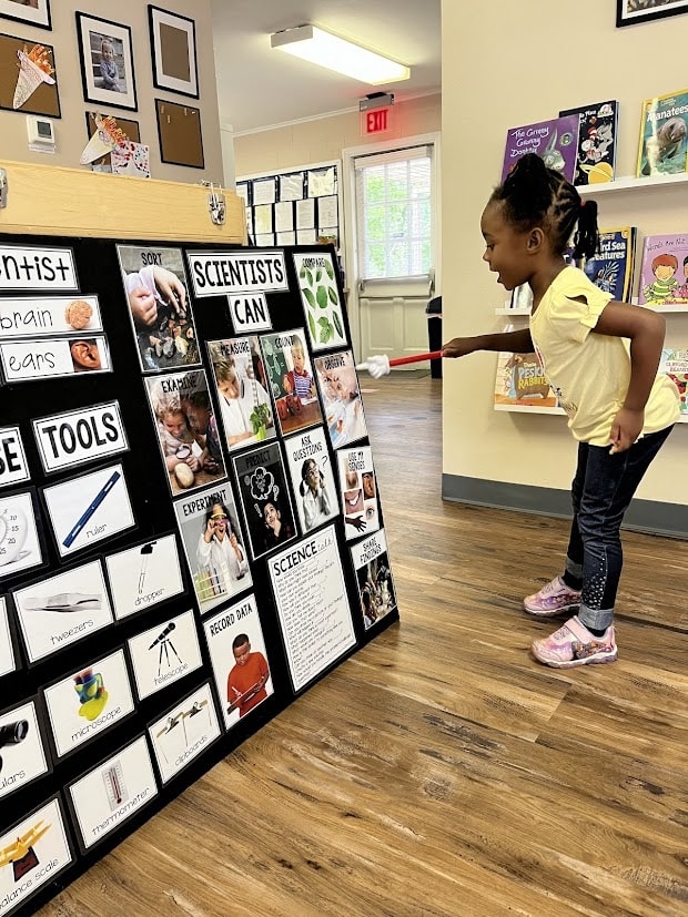 Preschool student presenting what scientist go to their classmates as an example of montessori peer teaching